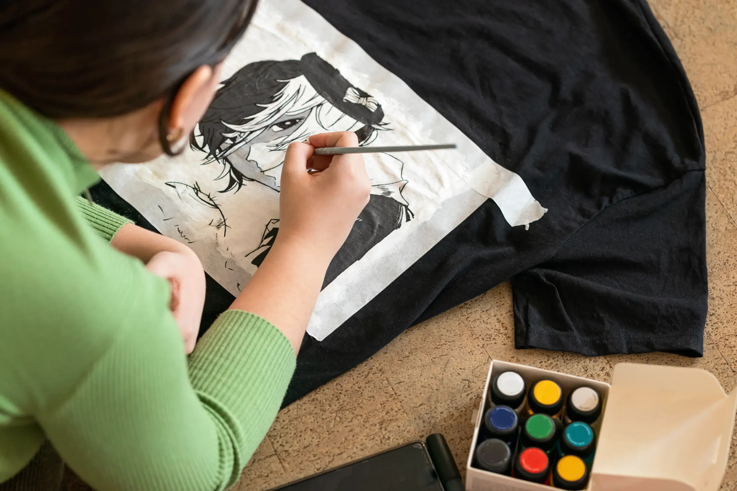 person-painting-an-anime-character-on-a-t-shirt-2026-03-18-12-03-43-utc